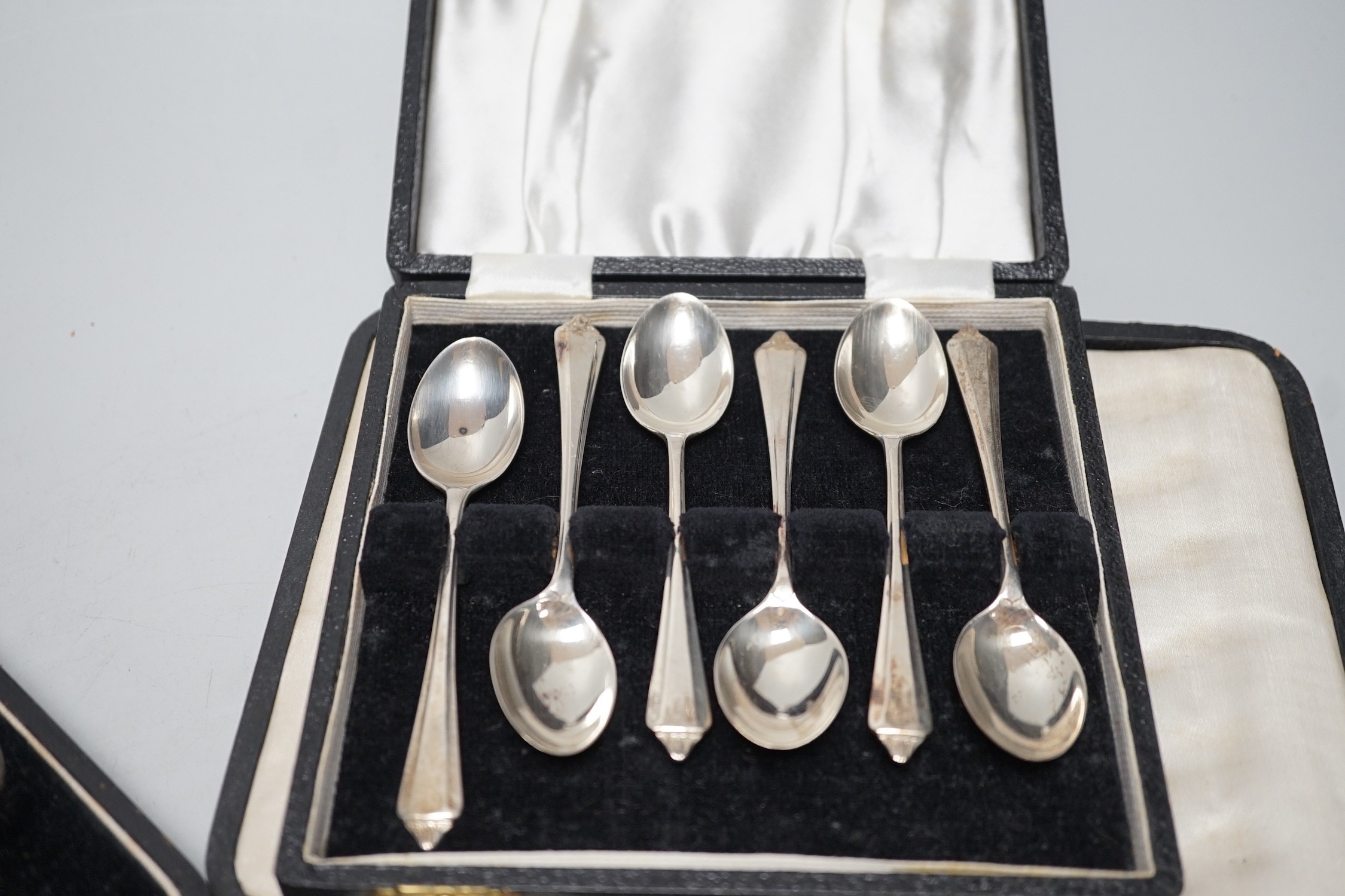 A cased George V three piece silver condiment set, Birmingham, 1928 and two other cased sets of flatware.